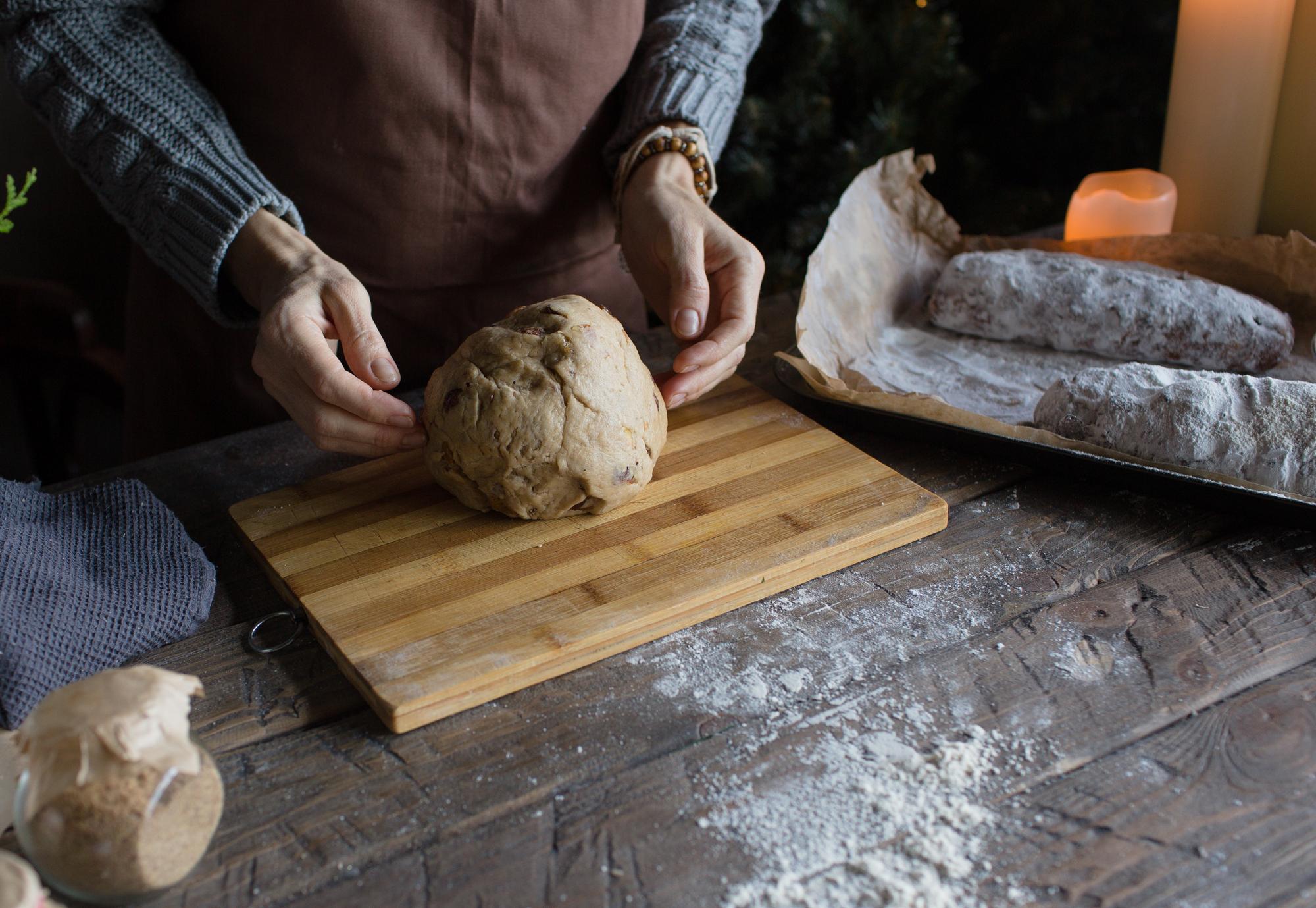Dettaglio mani che impastano in cucina professionale